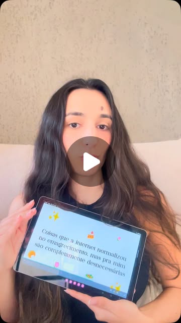 Reels: Tainá segurando um tablet com a frase Coisas que a internet normalizou no emagrecimento, mas pra mim são completamente desnecessárias
